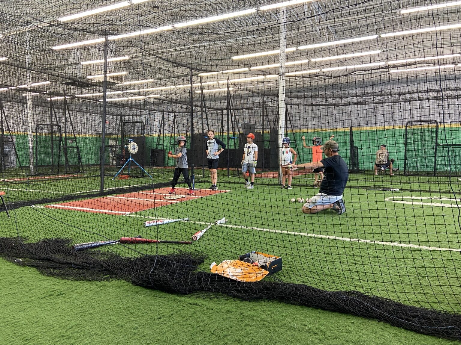 Coach instructing athletes in a cage
